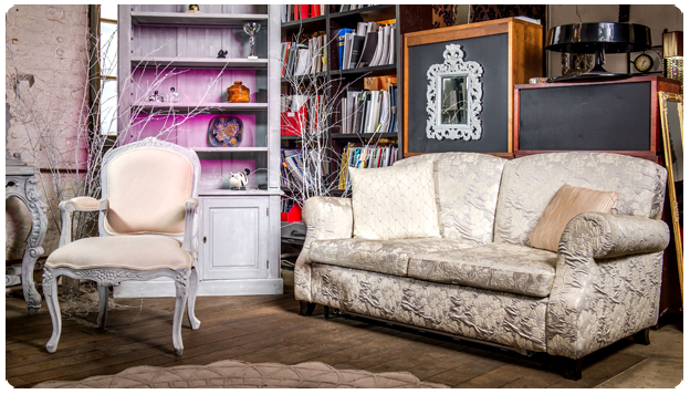 Finished living room with a restored carved armchair frame and newly upholstered sofa