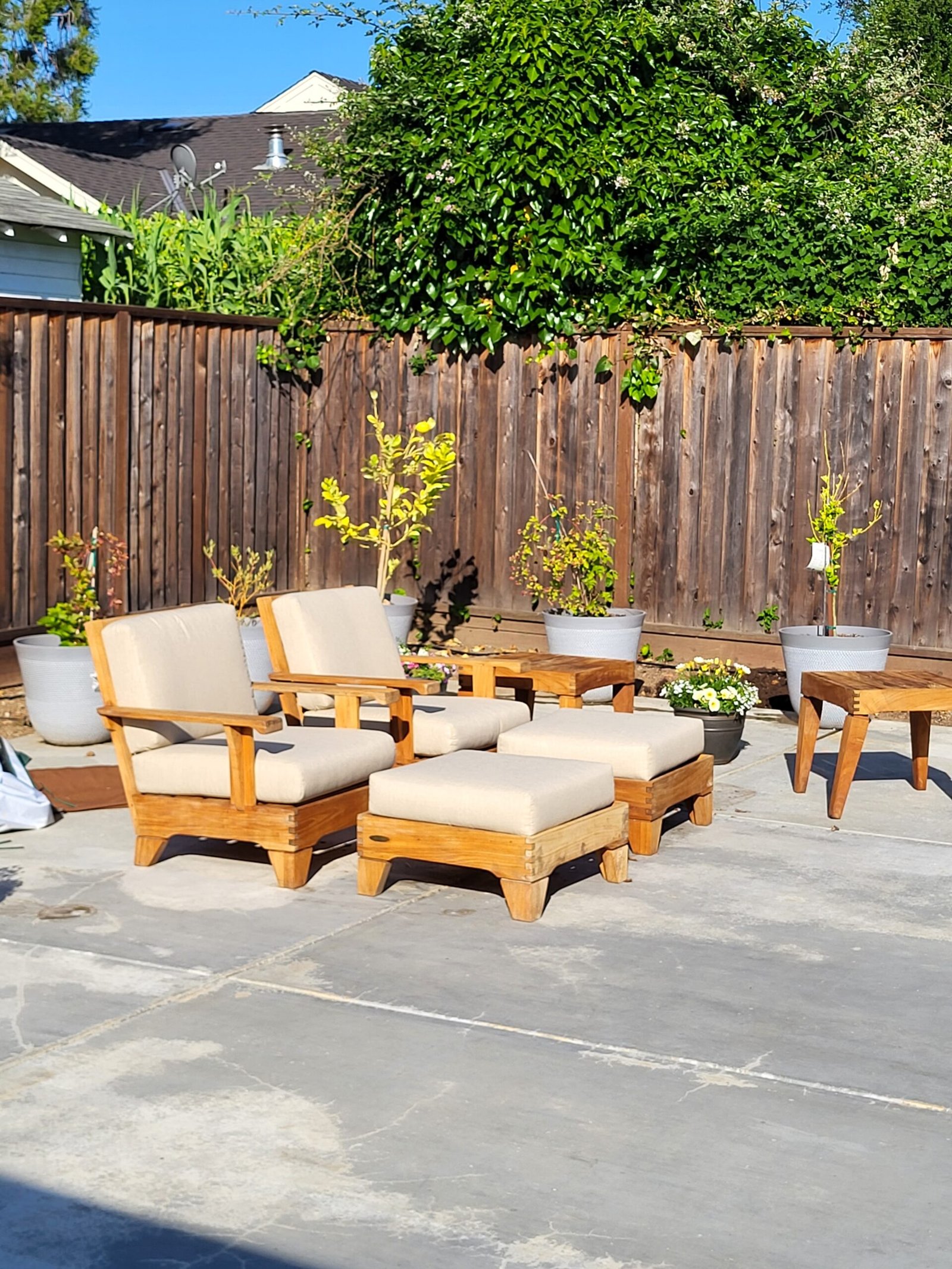Teak patio lounge chairs and ottomans with newly made cream outdoor cushions