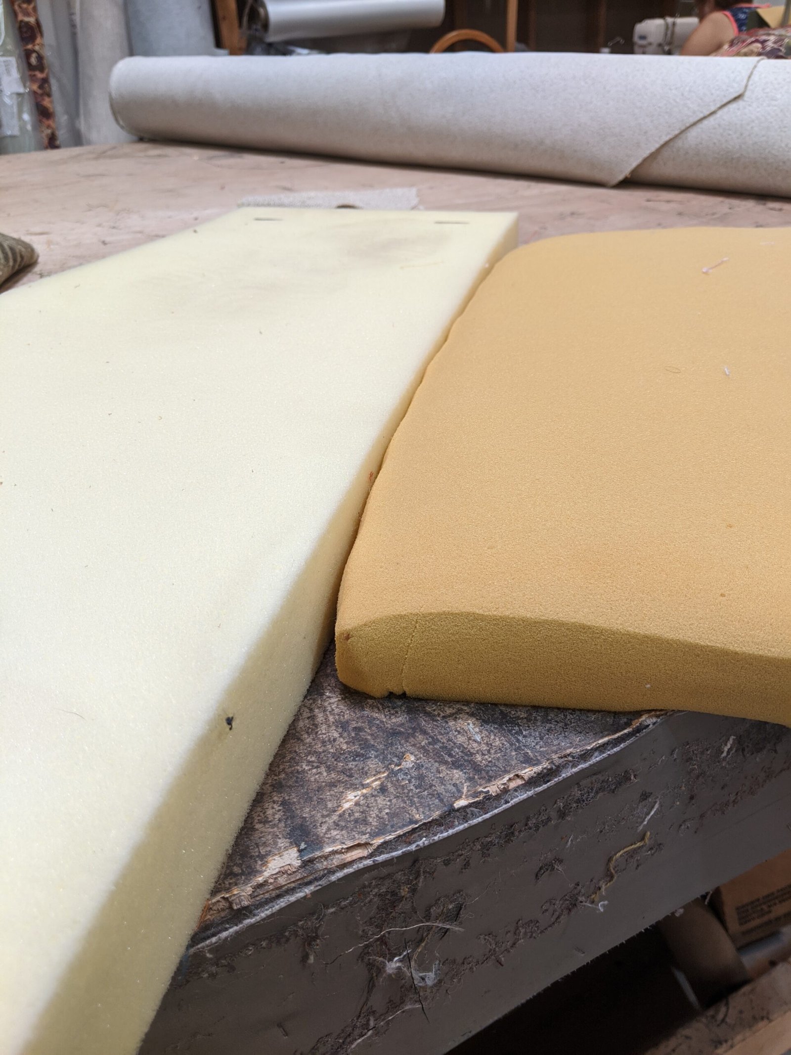 Two grades of upholstery foam laid out on a workbench for comparison